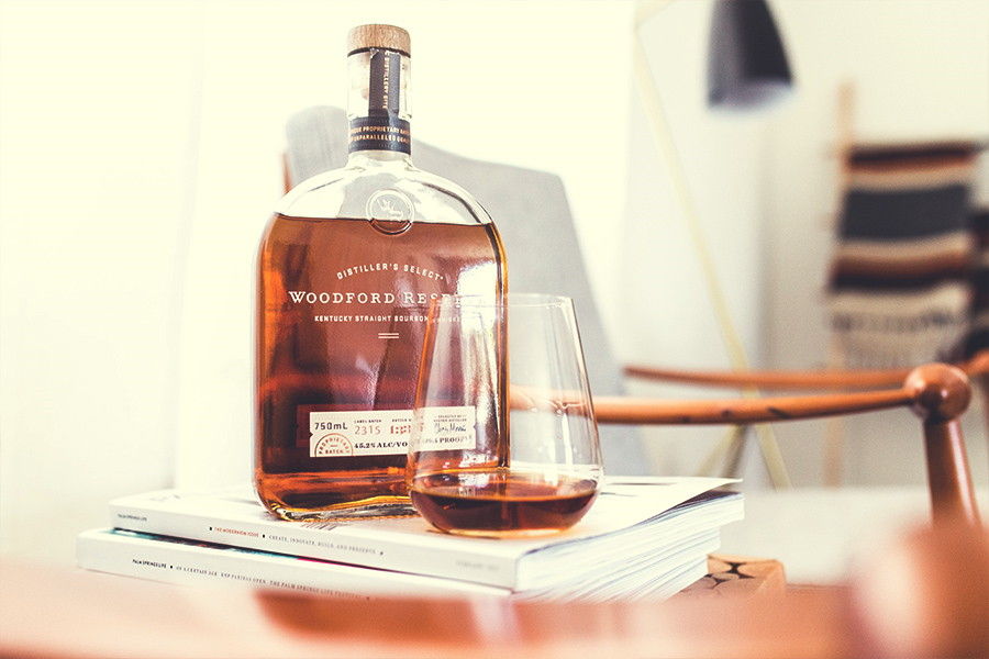 bottiglia di bourbon con bicchiere su un tavolo
